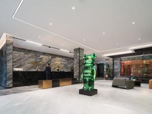 a green statue in the middle of a lobby at Park Inn by Radisson Hanzhong Central Square & High speed rail station in Hanzhong