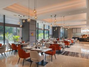 un restaurant avec des tables et des chaises dans une salle dans l'établissement Park Inn by Radisson Wenzhou Longwan International Airport Wanda Plaza, à Xingqianjie