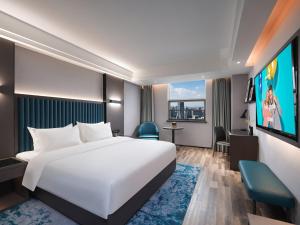 a hotel room with a bed and a tv at Park Inn by Radisson Hanzhong Central Square & High speed rail station in Hanzhong