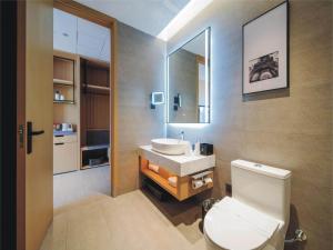 y baño con aseo blanco y lavamanos. en Park Inn by Radisson Jilin Beishan Park&Songhua River, en Jilin