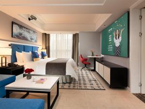 a hotel room with a bed and a tv at Park Inn by Radisson Beihai Silver Beach Wanda Plaza in Beihai