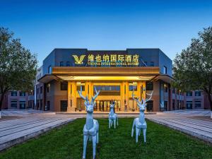 dos estatuas de ciervos falsos frente a un edificio en Vienna International Hotel Xianyang International Airport Hotel, en Xianyang