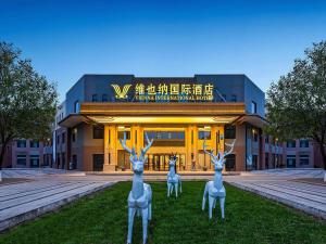 zwei vorgetäuschte Hirschstatuen vor einem Gebäude in der Unterkunft Vienna International Hotel Xianyang International Airport Hotel in Xianyang