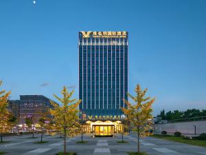 een hoog gebouw met een prieel op een parkeerplaats bij Vienna International Hotel Chengdu Shuangliu Airport Terminal Beijing Hualian in Chengdu
