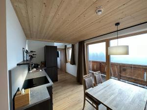 - une cuisine et une salle à manger avec une table et des chaises dans l'établissement Dorferwirt, à Bramberg am Wildkogel