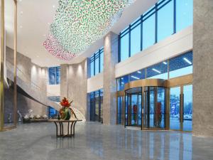 a lobby of a building with a chandelier at Park Inn by Radisson Nanchong Yilong Star City Plaza in Yilong