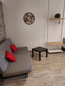 uma sala de estar com um sofá e um relógio na parede em Murena Apartments & rooms em Roma