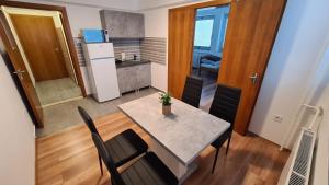 kuchnia i jadalnia ze stołem i krzesłami w obiekcie HÉDER APARTMANOK w mieście Balatonfenyves