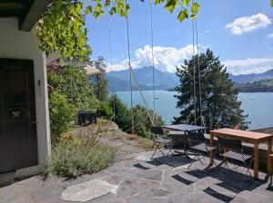 een tafel en stoelen met uitzicht op een meer bij Charming house with a lake view in Luzern