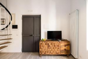 een woonkamer met een televisie op een houten kast bij Casa Mameli by Wonderful Italy in Conversano