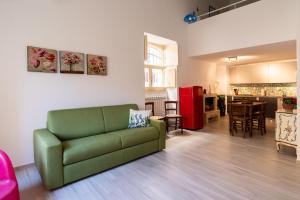 een woonkamer met een groene bank en een keuken bij Casa Mameli by Wonderful Italy in Conversano