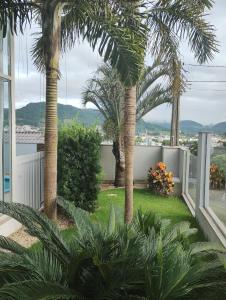 un jardín con palmeras y plantas en una casa en Ótimo quarto, requinte., en Rio do Sul