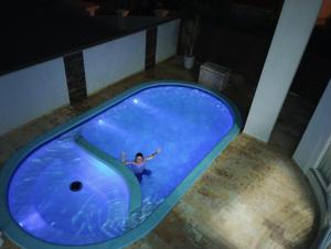 a person in a swimming pool with a shark in a bath tub at Ótimo quarto, requinte. in Rio do Sul