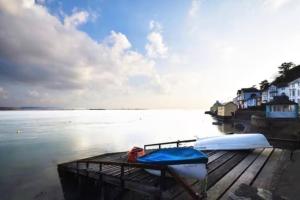 a boat sitting on a dock next to a body of water at Isfryn, holiday home in Aberdyfi in Aberdyfi