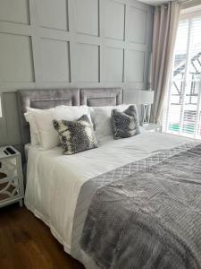a bedroom with a large white bed with pillows at Isfryn, holiday home in Aberdyfi in Aberdyfi +14 photos