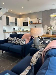 a living room with two blue couches and a table at Isfryn, holiday home in Aberdyfi in Aberdyfi