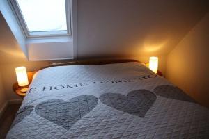 Un dormitorio con una cama con dos corazones. en Ferienwohnung Möwenschiss - Haus Bake, en Büsum