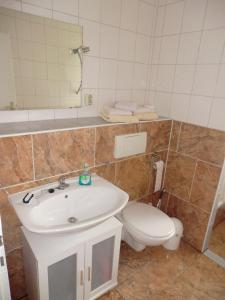 a bathroom with a white sink and a toilet at Appartementhof Fastnacht am See in Leuengarten