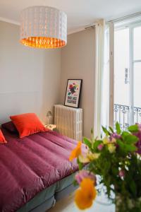 Un dormitorio con una cama con sábanas rojas y una ventana. en Appartement 11 place d'Alliance, en Nancy