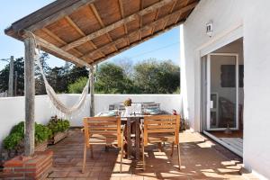 un patio con mesa, sillas y pérgola de madera en Varadero Beach Penthouse, en Los Caños de Meca