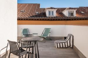 d'un balcon avec des chaises, des tables et un toit. dans l'établissement BYPILLOW Crosstown, à Madrid