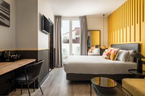 une chambre d'hôtel avec un lit et un salon dans l'établissement BYPILLOW Crosstown, à Madrid