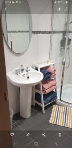 een badkamer met een wastafel, een spiegel en een douche bij CASTLE-VIEW in Castlerock