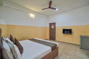 a bedroom with a bed and a ceiling fan at 14 Door Home Stay in Calangute