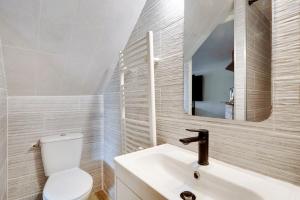 ein Badezimmer mit einem WC, einem Waschbecken und einem Spiegel in der Unterkunft Paris Marais Best WE MERRIS in Paris