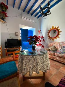 ein Wohnzimmer mit einem Tisch und einer Blumenvase darauf in der Unterkunft Casa en Alcazaba in Almería