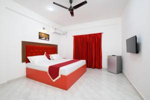 a bedroom with a red bed and a red curtain at 14 Door Home Stay in Calangute