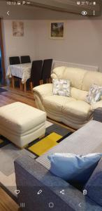 una sala de estar con sofás y una mesa con sillas. en CASTLE-VIEW en Castlerock