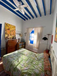 Un dormitorio con una cama y un ventilador de techo. en Casa en Alcazaba, en Almería