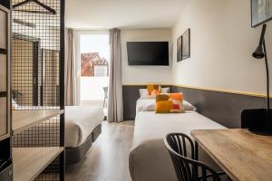 une chambre d'hôtel avec deux lits et une table dans l'établissement BYPILLOW Crosstown, à Madrid