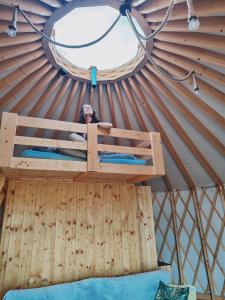 a person in a wooden bed in a yurt at Glamping Niebiańska Osada Jurty Dolnośląskie in Wolany