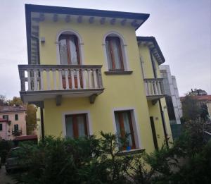 une maison jaune avec un balcon au-dessus dans l'établissement Residence Villa Rendina, à Mestre