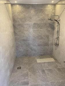 a bathroom with a shower with a stone wall at منتجع ريتام in Al Ahsa