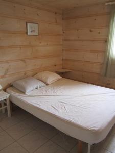 uma cama num quarto com uma parede de madeira em GASMED41 Golfe de Saint-Tropez - Chalet californien 3 chambres pour 8 personnes em Gassin