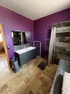a purple bathroom with a sink and a shower at Le Séchoir un Grand coin de paradis in Saint-Amand-de-Coly