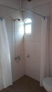 a bathroom with a shower with a toilet and a window at POSADA DE LA LUNA in Ciudad Lujan de Cuyo