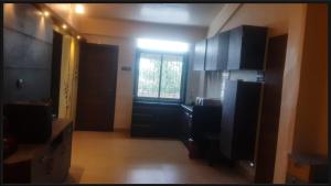 a kitchen with black cabinets and a window at 2bhk Apartment with 1900sq ft Private Terrace in Lonavala in Malavli +9 photos