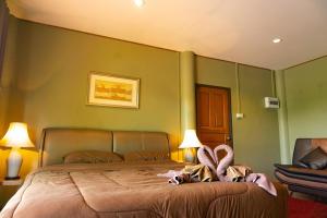 una camera da letto con un grande letto con pareti verdi di Kwainoy Riverpark a Sai Yok