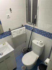 a bathroom with a white toilet and a mop at Plaza Rio B in Madrid