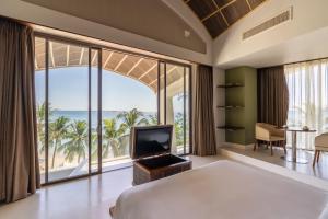 a bedroom with a bed and a view of the ocean at The Shells Resort & Spa Phu Quoc in Phú Quốc