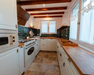 a kitchen with white cabinets and a stove top oven at Home - Retour aux sources in Le Ménil +20 photos