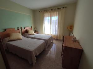 的住宿－LA CASA NUEVA，一间卧室设有两张床和窗户。