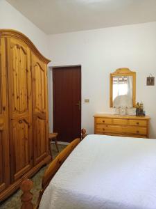 Schlafzimmer mit einem Bett, einer Kommode und einem Spiegel in der Unterkunft villa modica casteltermini in Casteltermini