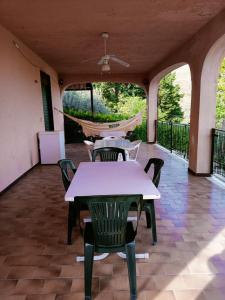 eine Terrasse mit Tischen, Stühlen und einer Hängematte in der Unterkunft villa modica casteltermini in Casteltermini