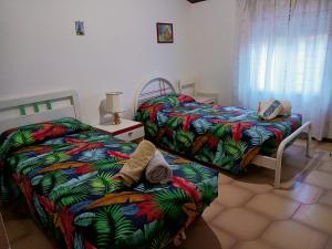 ein Schlafzimmer mit 2 Betten und einem Tisch mit einer Lampe in der Unterkunft villa modica casteltermini in Casteltermini