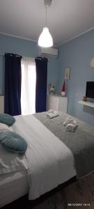 a blue bedroom with a large bed with blue walls at MarilidiaHouse in Kardhoulianós